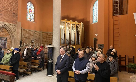 Widok słuchaczy UTW stojących i modlących się w czasie Mszy Świętej w kościele pw. św. Marcina we Wrocławiu